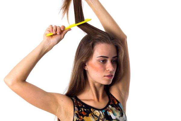 Mujer joven cepillándose el pelo largo — Foto de Stock