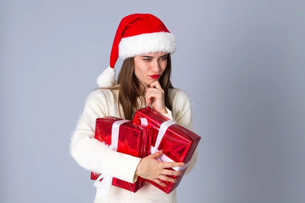 선물을 들고 빨간 크리스마스 모자에 있는 여자 — 스톡 사진