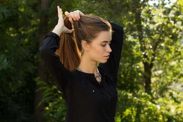 Giovane donna che fissa i capelli — Foto Stock