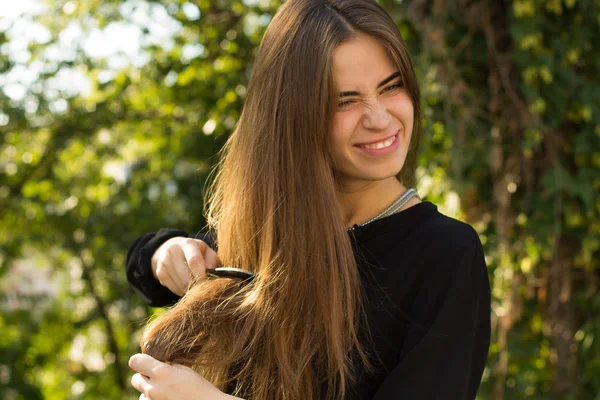 Mulher penteando seu cabelo no parque — Fotografia de Stock