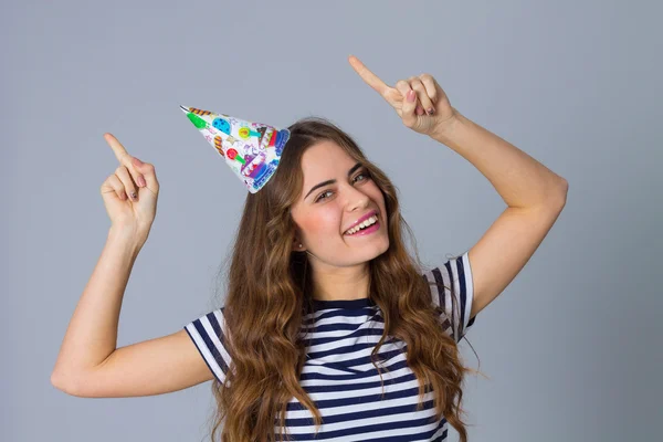 Woman in celebration cap holding hands up — Stock Photo, Image