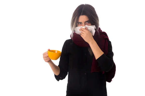 Mujer sosteniendo una taza y sonándose la nariz — Foto de Stock