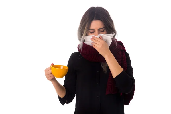 Mujer sosteniendo una taza y sonándose la nariz — Foto de Stock