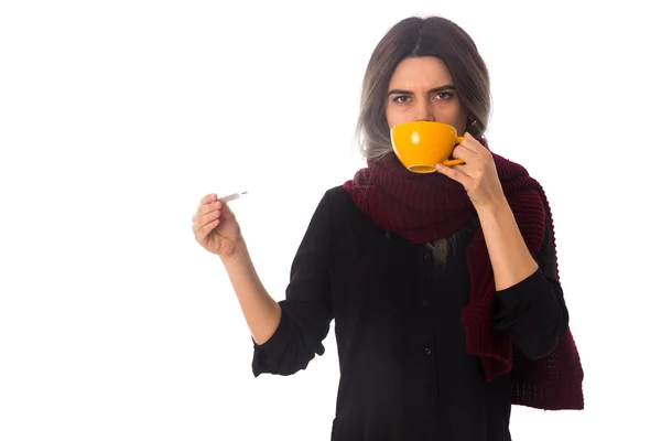 Mujer bebiendo y sosteniendo un termómetro — Foto de Stock