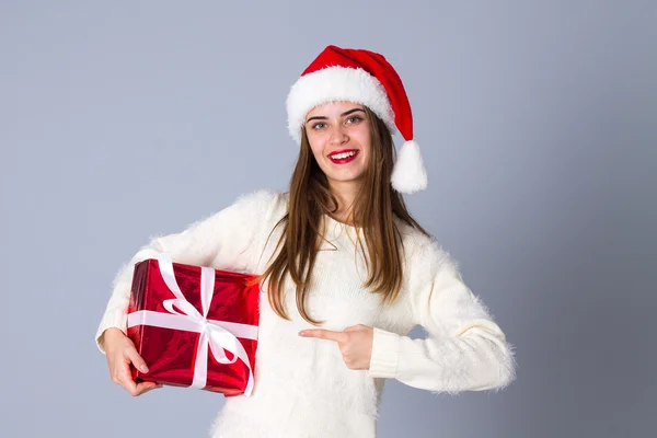 红色的圣诞帽，拿着礼物的女人 — 图库照片
