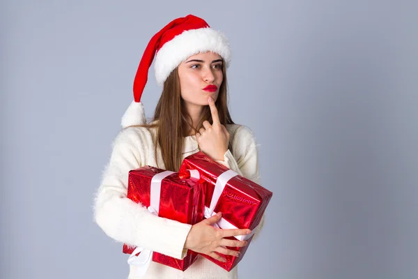 プレゼントを押し赤いクリスマス帽子の女 — ストック写真