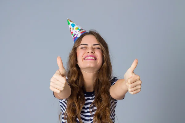 Woman in celebration cap showing thumbs up — Φωτογραφία Αρχείου