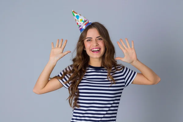 Frau mit Feiermütze hält die Hände hoch — Stockfoto