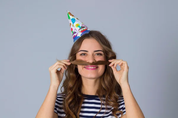 Frau mit Feiermütze macht Schnurrbart — Stockfoto