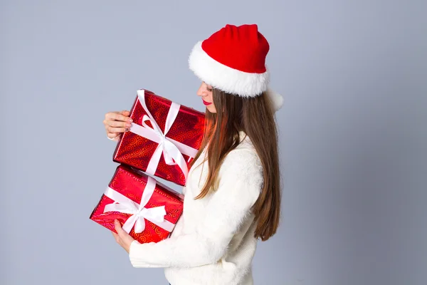 Γυναίκα με κόκκινο καπέλο Χριστουγέννων κρατώντας δώρα — Φωτογραφία Αρχείου