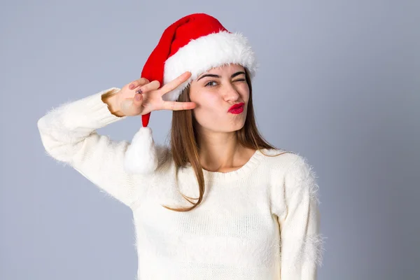 Kvinna i röd jul hatt visar fred — Stockfoto