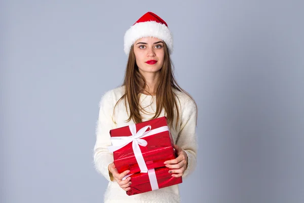 Woman in red christmas hat holding presents — Stock Photo, Image