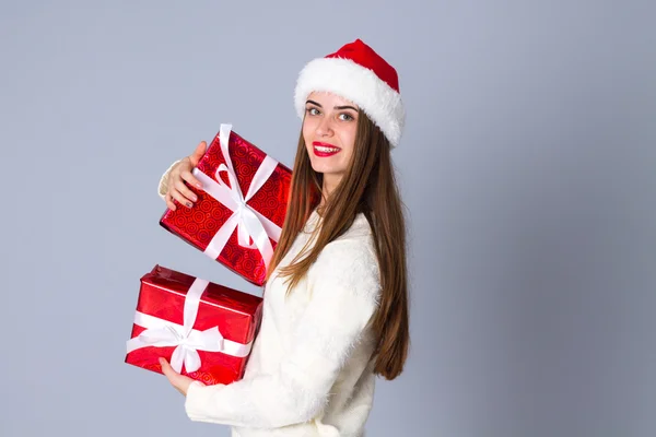 Женщина в красной рождественской шляпе с подарками — стоковое фото