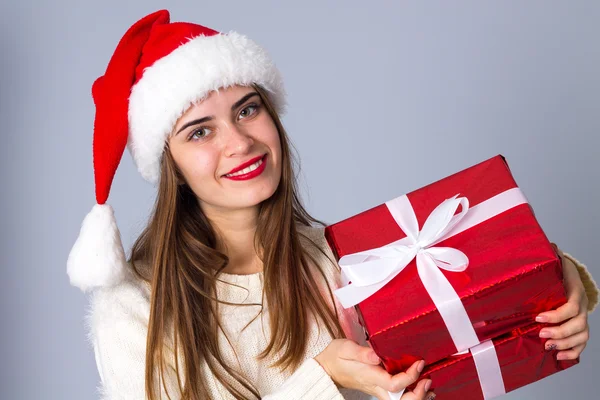 Woman in red christmas hat holding presents — Stock Photo, Image