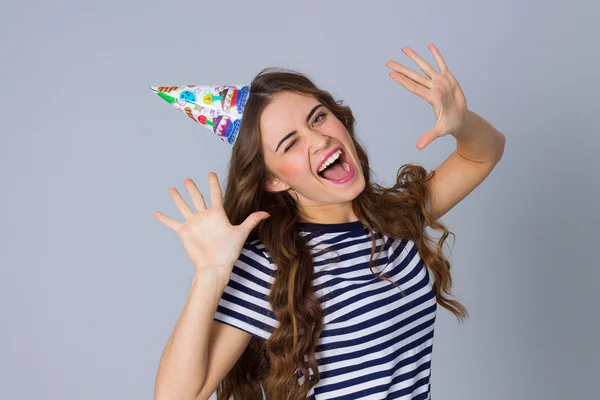 Mulher sorridente com cabelo comprido em boné de celebração — Fotografia de Stock