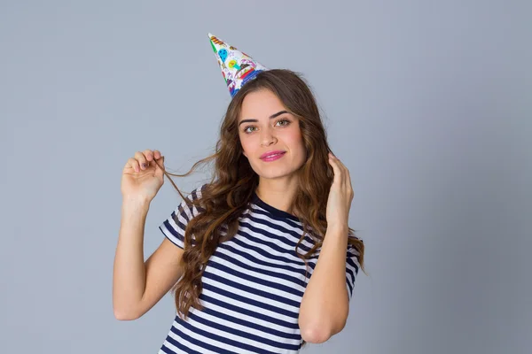 Mujer en celebración gorra tocando su pelo largo — Foto de Stock