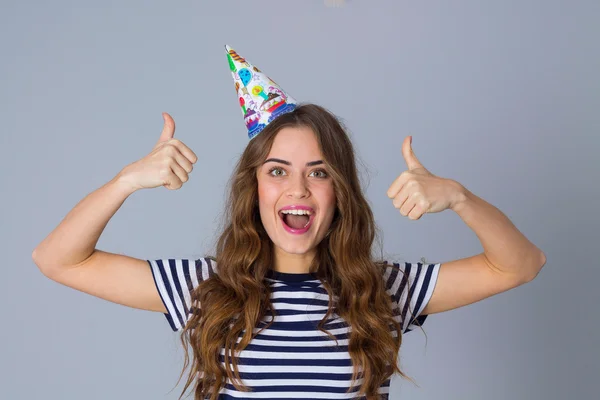 Woman in celebration cap showing thumbs up — Φωτογραφία Αρχείου