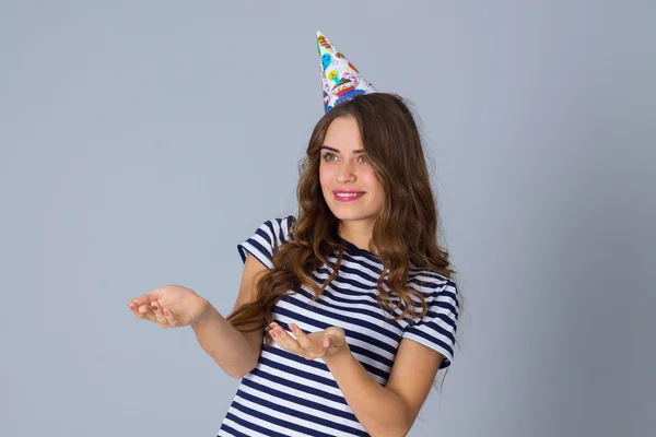 Woman in celebration cap holding hands in front of her — Stockfoto