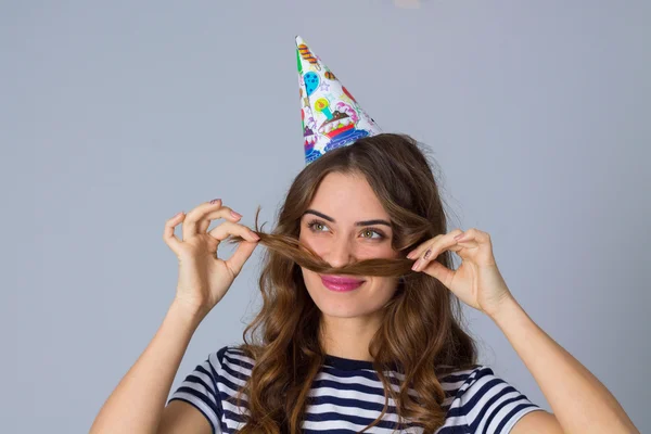 Frau mit Feiermütze macht Schnurrbart — Stockfoto