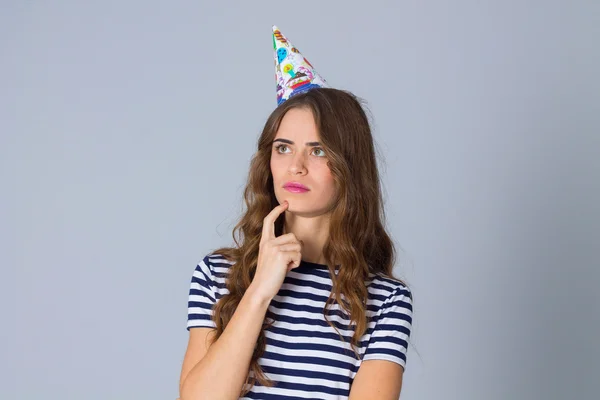 Woman in celebration cap thinking — Stockfoto