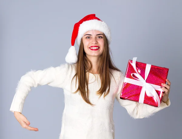 Woman in red christmas hat holding presents — Stock Photo, Image