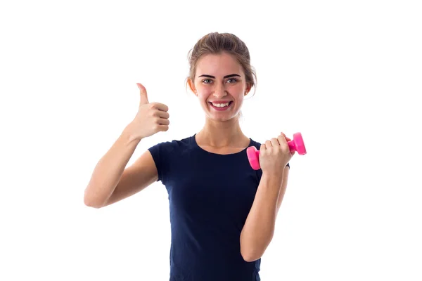 Woman holding a dumbbell and showing thumb up — Stock Photo, Image