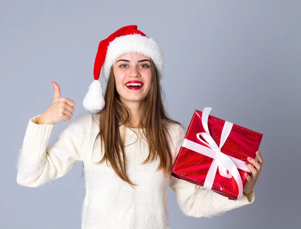 Vrouw in rode kerstmuts houden presenteert — Stockfoto