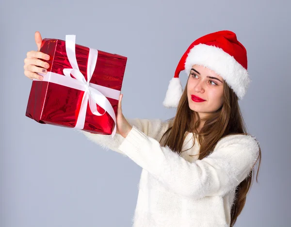 Kvinna i röd jul hatt hålla presenterar — Stockfoto