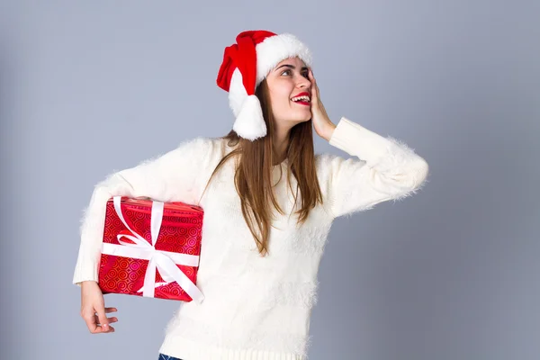 Kırmızı Noel şapka holding kadında sunar — Stok fotoğraf