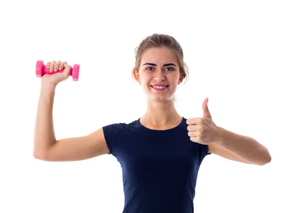 Woman holding a dumbbell and showing thumb up — Stock fotografie
