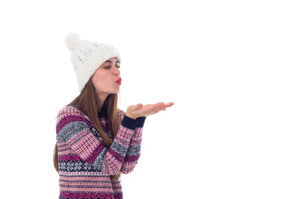 Woman in sweater and white hat blowing — Stock Photo, Image