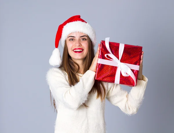 Woman in red christmas hat holding presents — Stock Photo, Image