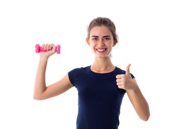 Bir dumbbell tutarak ve başparmak gösterilmesini kadın