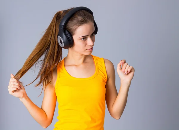 Jovem mulher em fones de ouvido — Fotografia de Stock