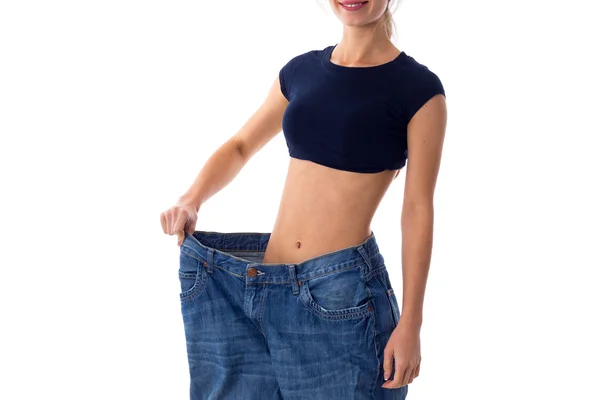 Woman wearing jeans of much bigger size — Stock Photo, Image