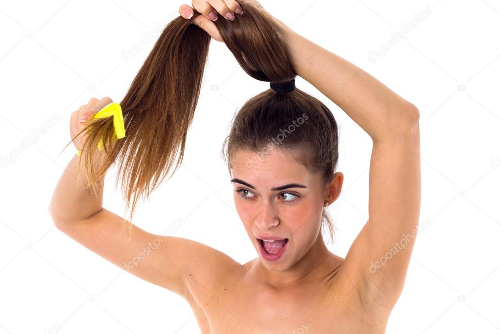 Young woman combing her long ponytail