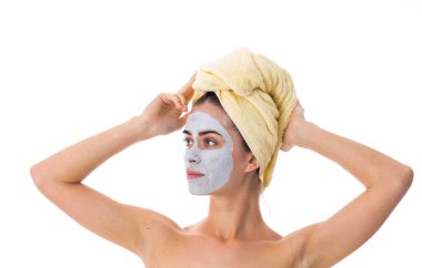 Havlu kafa ve kozmetik maskesi yüzünde kadınla