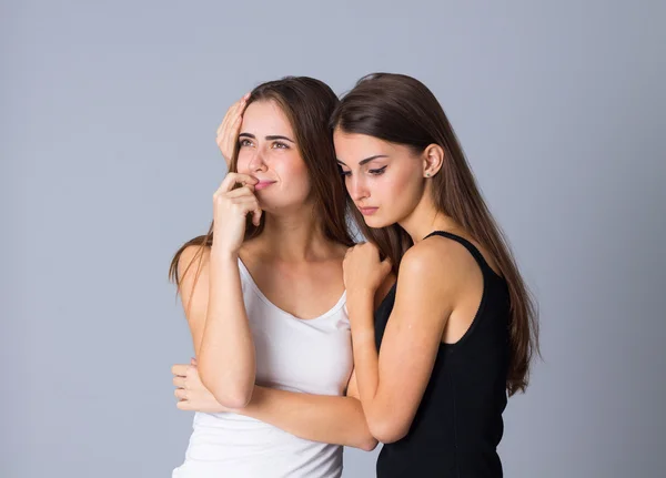 Uma mulher chorando e outra abraçando-a — Fotografia de Stock