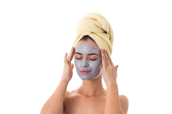 Mulher com toalha na cabeça e máscara cosmética no rosto — Fotografia de Stock