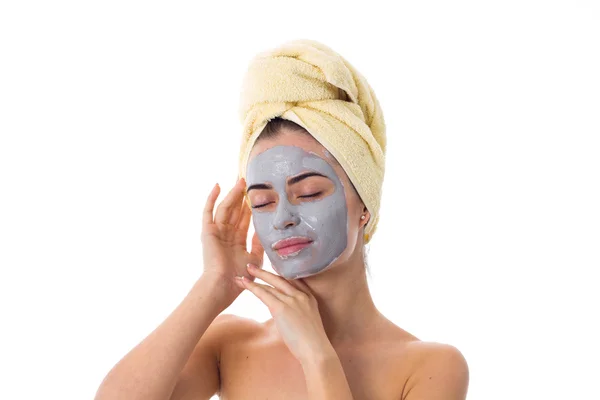 Vrouw met handdoek op haar hoofd en cosmetische masker op haar gezicht — Stockfoto