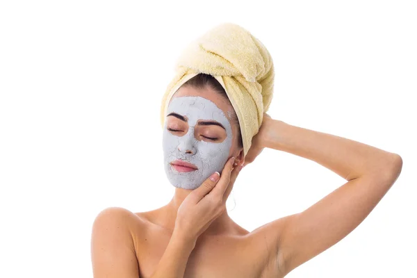 Donna con asciugamano sulla testa e maschera cosmetica sul viso — Foto Stock