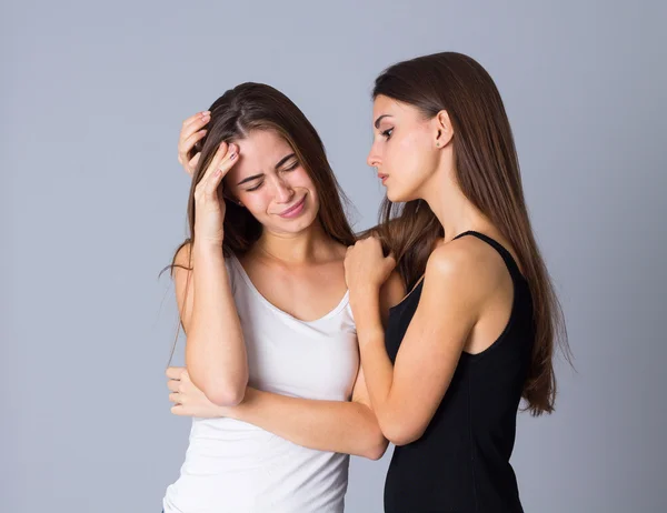 Uma mulher chorando e outra abraçando-a — Fotografia de Stock