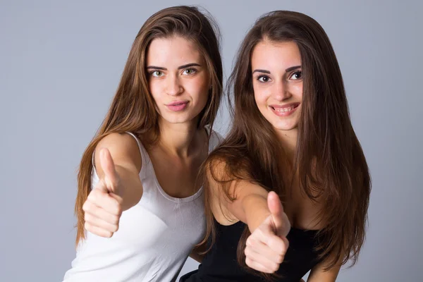 Duas mulheres jovens mostrando polegares para cima — Fotografia de Stock