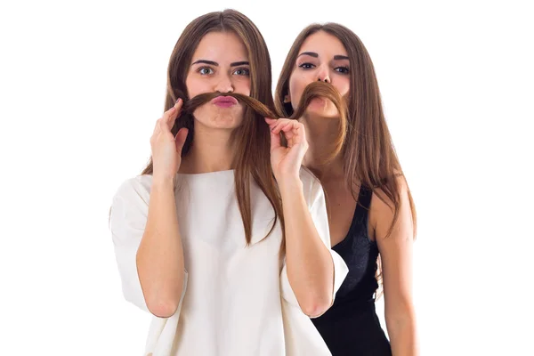 Dos mujeres jóvenes haciendo bigote de su pelo —  Fotos de Stock