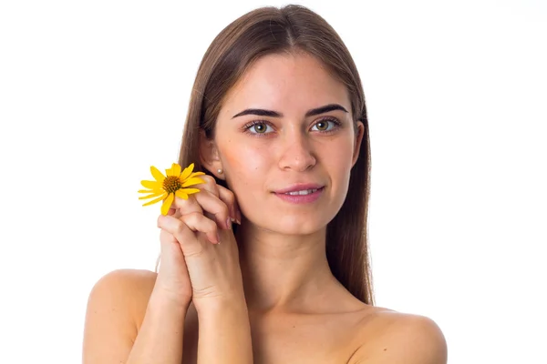 Jovem com cabelo comprido segurando flor amarela — Fotografia de Stock