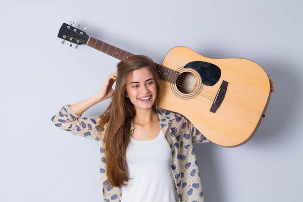Mujer joven sosteniendo una guitarra —  Fotos de Stock