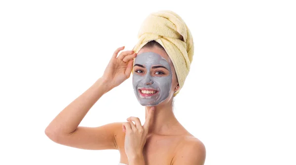 Femme avec serviette sur la tête et masque cosmétique sur le visage — Photo