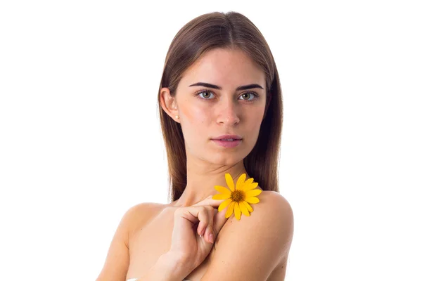 Νεαρή γυναίκα με μακριά μαλλιά, κρατώντας κίτρινο λουλούδι — Φωτογραφία Αρχείου