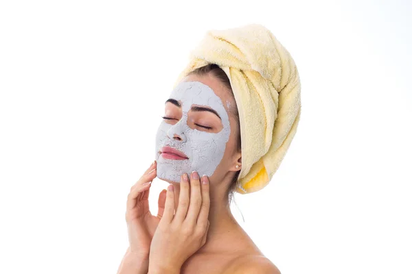 Vrouw met handdoek op haar hoofd en cosmetische masker op haar gezicht — Stockfoto