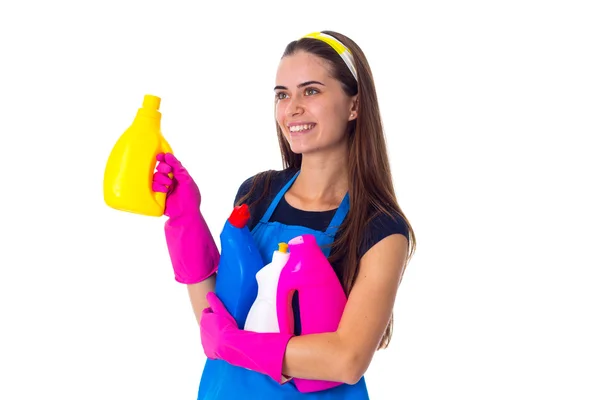 Жінка в фартусі тримає миючі засоби — стокове фото